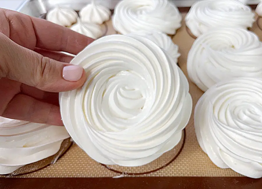 A hand holding the baked meringue nest