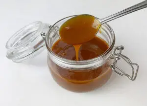 Runny caramel dripping from a spoon
