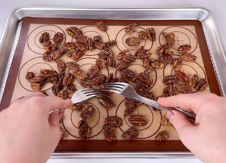 When the nuts are done, transfer them onto the prepared baking sheet into one single layer.
