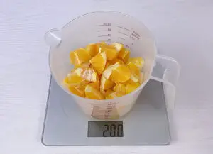 A cup with the orange flesh on the scale