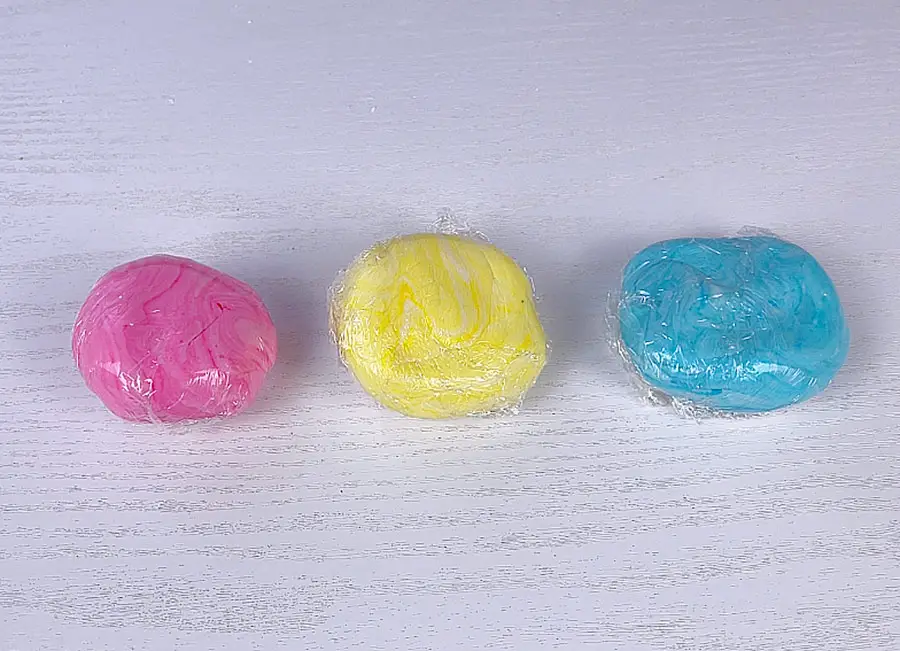 Colored marshmallow dough covered with plastic wrap
